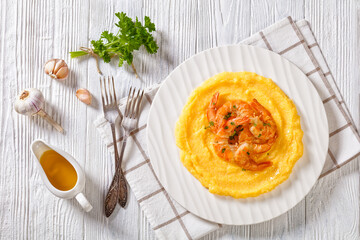 polenta with fried shrimps on plate, top view
