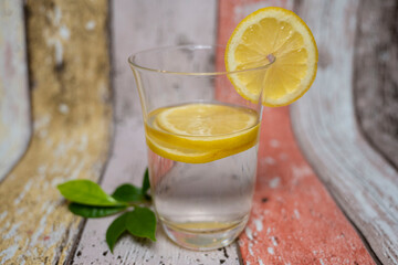 verre d'eau avec des tranches de citron et feuilles de citronnier