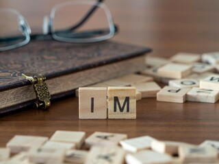 the acronym im for instant message word or concept represented by wooden letter tiles on a wooden...