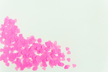 Valentines day composition. White background with pink heart shape confetti. Top view. Copy space
