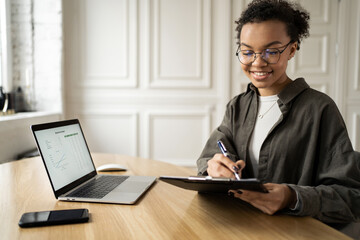 Freelancer with glasses woman works start-up in office coworking space, uses laptop computer