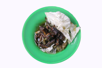 green chili eel dish on a green plate, fried eel topped with garlic and cabbage. clipping path