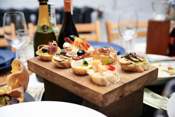 Festive table with delicious appetizers and snacks. Holiday banquet serving with fancy glasses and silverware in restaurant. Wedding birthday party celebration.