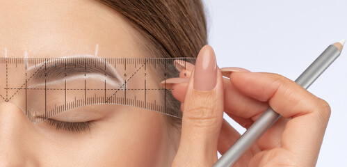 Make-up artist makes markings with white pencil for eyebrow and paints eyebrows. Professional...