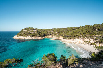 Fototapeta na wymiar View of Mitjaneta beach with beautiful turquoise sea water, Menorca island, Spain 