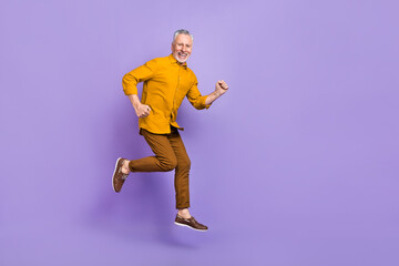 Fototapeta na wymiar Full body profile side photo of senior man runner jumper rush motion isolated over purple color background