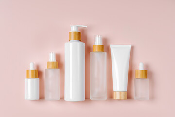 Cosmetic container mockups for branding and packaging presentation. Pump bottle, cream tube, and dropper on pastel background. Natural skincare beauty product concept.