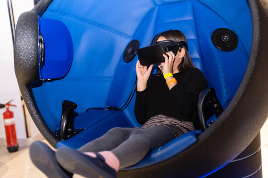 Child with virtual reality headset sitting in a chair booth