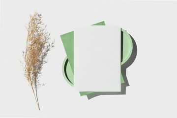 Blank greeting card, invitation mockup. Dry grass, pampas plant on white table background. Flat...