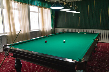 Billiard table with green cloth. Billiard room. Board game. Billiard club for relaxing in your free...