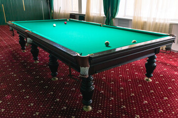 Billiard table with green cloth. Billiard room. Board game. Billiard club for relaxing in your free...