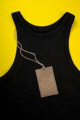 price tag hang over black t-shirt on  yellow background - Image