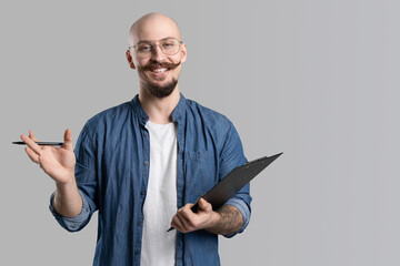 Image of handsome balded with musctache and beard happy man wearing casual clothes holding...