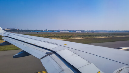 Fototapeta na wymiar aircraft running at runway with bright blue sky at morning from flat angle