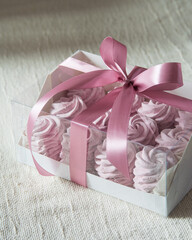 Homemade russian marshmallow - zephyr in white paper box on light linen tablecloth, selective focus