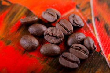 Obraz premium Kaffeebohnen auf rotem Untergrund in Nahaufnahme