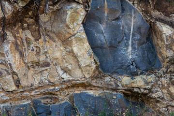 Naklejka premium View of rocks broken down for construction in a hilly region. Remains of rock in a quarry