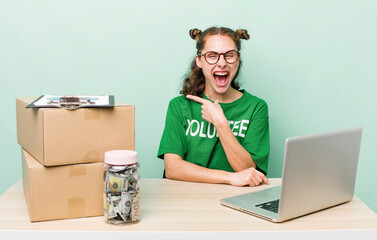 young pretty woman  looking excited and surprised pointing to the side. donation volunteer concept
