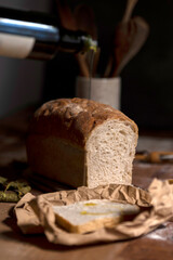 Homemade sourdough bread with seeds in different shapes and styles with olive oil on a still life table with a cloth rolling pin and window light