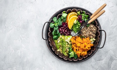 Quinoa salad in bowl with avocado, sweet potato, beans on gray background. superfood concept. Healthy, clean eating concept. Vegan or gluten free diet. top view