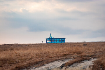 isolated church at yellow grass field with dramatic sky at morning from different angle