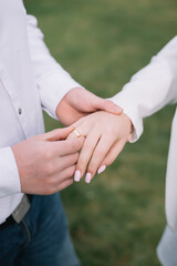 The groom wears a wedding ring on the bride. Closeup photo