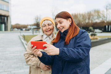 Womens use smartphone to find what they are interested in outdoors. Searching information data on internet, networking concept. Friends watching videos on a smartphone