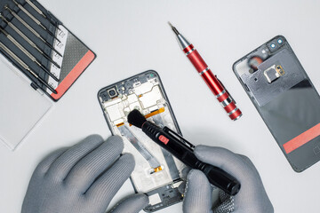 Technician repair and cleaning dirty smartphone in lab.
