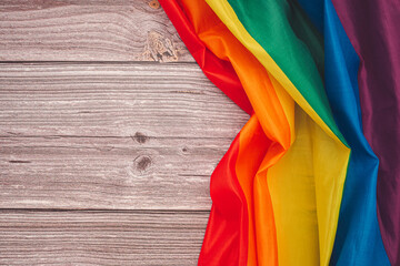 Top view of the rainbow flag or LGBT over a wooden table