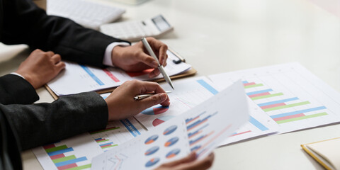 Consult financial concept. Business woman pointing at paperwork and using calculator.