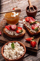 toasts or bruschetta with strawberry and mint on cream cheese ricotta. Delicious breakfast or snack, top view
