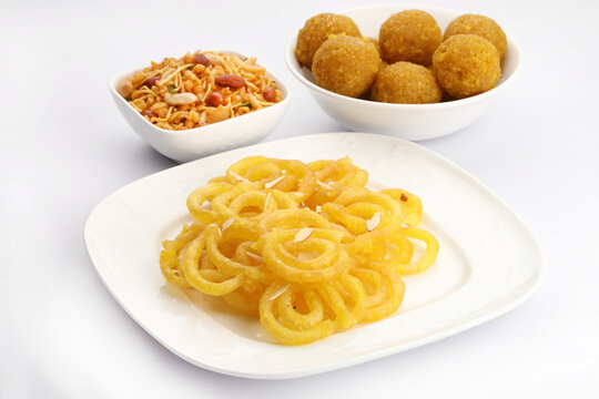 Jelebi famous Indian sweet (tradtional Indian fried sweet dessert) & Chivda or bujiya or namkin & bundi laddu with flowers in a basket