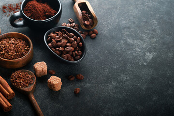 Coffee beans background. Roasted Coffee concept with differents types of coffee, beans and cinnamon sticks on dark black stone background. Top view. Coffee concept. Mock up.