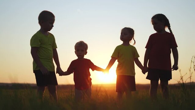 children join hands. children kid together walk in the park at sunset silhouette. people in park concept. baby and children joyful hold hands. happy family baby child summer kid dream concept fun