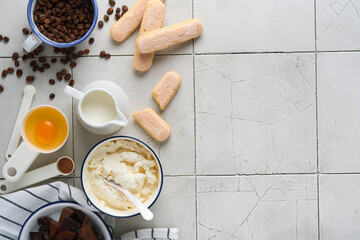 Tiramisu dessert. Ingredients for making dessert tiramisu. Cooking Italian food dessert Tiramisu with all necessary ingredients cocoa, coffee, mascarpone cheese on grey stone background. Copy space