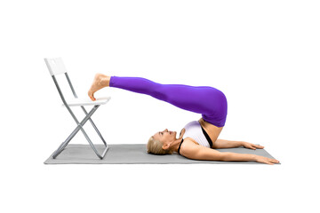 Inverted asana in Iyengar yoga with props. Caucasian woman practice plow pose using a chair,...