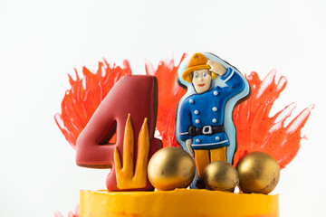 Birthday cake decorated with gingerbread cookies in the shape of a fire truck and a fireman for a...