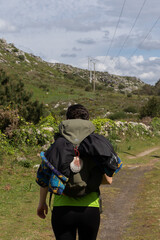 a backpacker doing hiking along a green path admiring the landscape