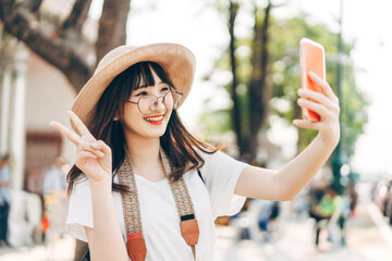 Young adult asian woman traveller selfie by mobile phone wear backpack chinatown street food market...