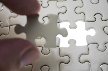 Hand holding jigsaw puzzle last missing piece lighting. 
Concept last piece of jigsaw puzzle for...