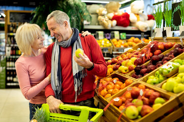 Happy senior family choosing eco fruits at store