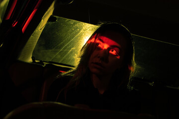 eyes of the model seen by red light in the car, night