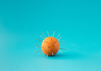 Fresh orange with nailed nails on blue background.