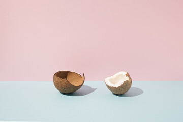 Broken coconut on pastel background.