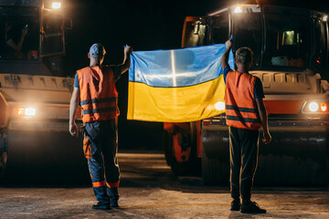 Two ukrainian young workers with Ukrainian flag in hands standing backwards	
