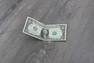 Dollar bill on a light wooden background