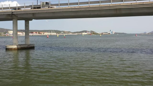 beautiful flight over the water under the bridge and towards the marina and the town of olbia in sardinia