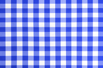 Blue checkered textile picnic tablecloth pattern in close-up. Background for classic cuisine style.