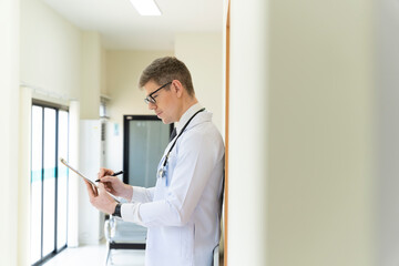 Fototapeta premium A handsome male doctor is leaning towards the hospital.