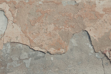 An old concrete wall background. A cement texture with cracked beige paint.